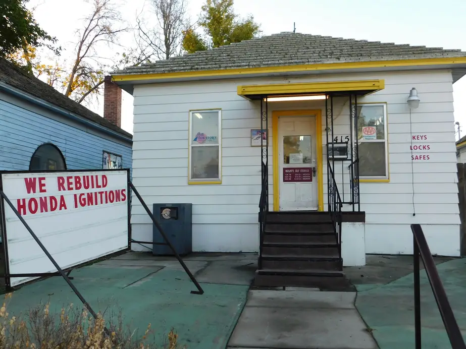 The front door of Mount's at 415 W 1st Ave with KEYS LOCKS SAFES lettered on the wall and a WE REBUILD HONDA IGNITIONS reader board