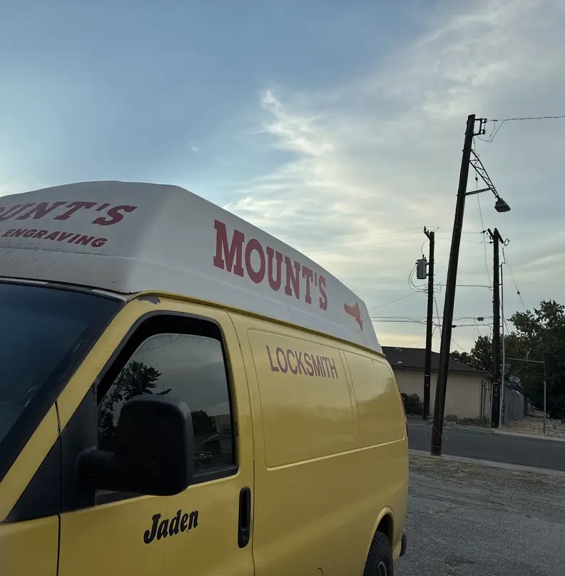 Mount's yellow locksmith van with MOUNT'S LOCKSMITH & ENGRAVING on the roof